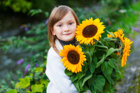 Adorable happy little girl holding boquet of sunflowersの写真素材