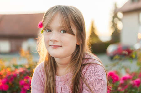 Close up portrait of a cute little girl resting outdoors on a nice sunny eveningの写真素材