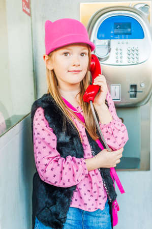 Outdoor portrait of a cute little girl in glasses, toned imageの写真素材
