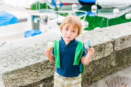 Adorable little boy eating ice cream on a nice summer dayの写真素材