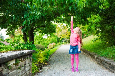 Outdoor portrait of adorable little girl playing in a parkの写真素材