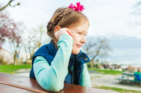 Close up portrait of adorable little girl resting in a parkの写真素材