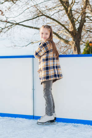 Cute little girl on skating rinkの写真素材