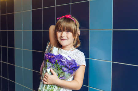 Portrait of a cute little girl with bouquet of aster autumn flowersの写真素材
