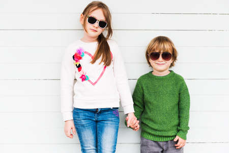 Fashion kids outdoors wearing pullovers and sunglassesの写真素材