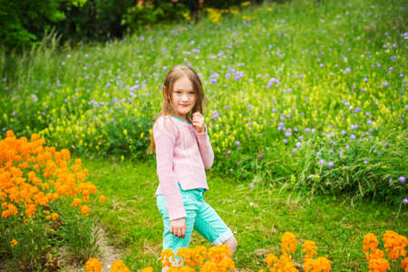 Cute little girl playing in a park wearing pink pulloverの写真素材
