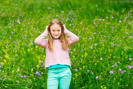 Cute little girl playing in a park wearing pink pulloverの写真素材