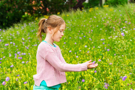 Cute little girl playing in a park wearing pink pulloverの写真素材
