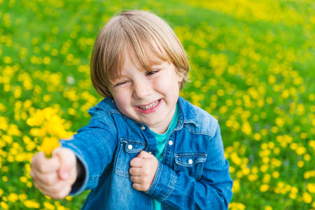 Cute little boy playing with flowers outdoorsの写真素材