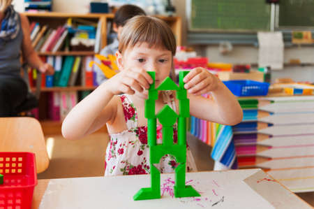 Cute little girl working in a classroomの写真素材