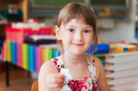 Cute little girl working in a classroomの写真素材