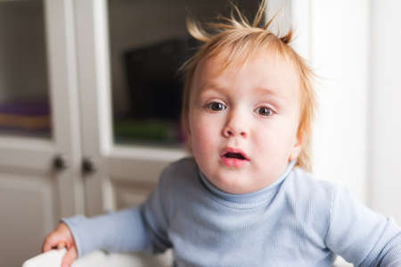 Indoor portrait of a cute little baby boy with funny hairstyleの写真素材