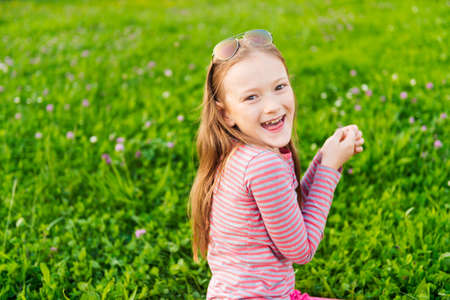 Portrait of a cute little girl of 7 years old in the parkの写真素材