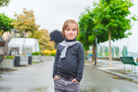 Outdoor portrait of a funny little boy under the rainの写真素材
