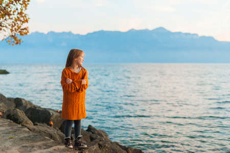 Cute little girl watching the sunset over the lakeの写真素材