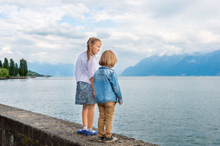 Outdoor portrait of cute little kids walking by the beautiful lakeの写真素材