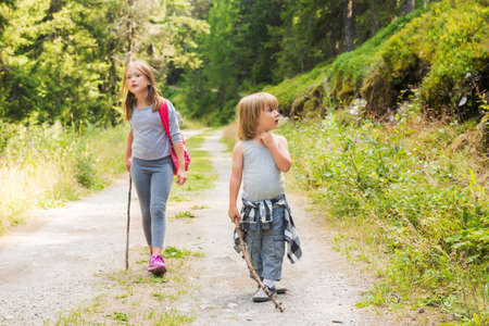 Two cute kids hiking in forestの写真素材