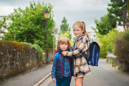 Cute kids with backpacks walking to school
