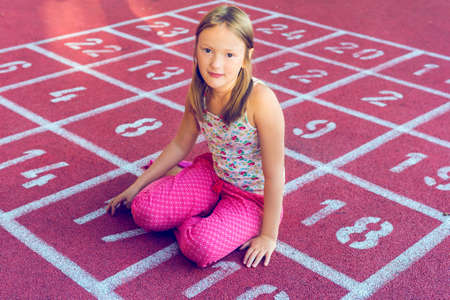 Portrait of adorable little girl on playground, toned image  
