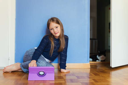 Adorable little girl playing on a digital tabletの写真素材