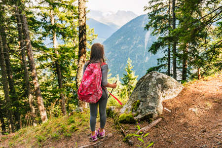 Cute little girl hiking in swiss Alps, admire amazing viewの写真素材