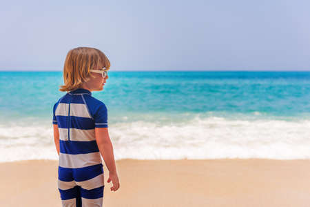 Adorable kid having fun on summer vacation, playing by the sea, back view,  image taken in Tropea, Calabria, Italyの写真素材