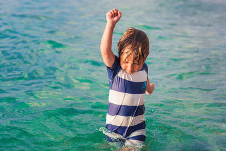 Adorable kid having fun on summer vacation, playing in the sea, image taken in Tropea, Calabria, Italyの写真素材