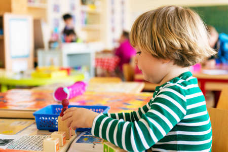 Indoor portrait of a cute little boy in a classroomの写真素材