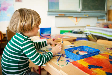 Indoor portrait of a cute little boy in a classroomの写真素材