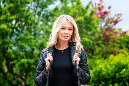 Outdoor portrait of beautiful blond woman wearing black leather jacketの写真素材