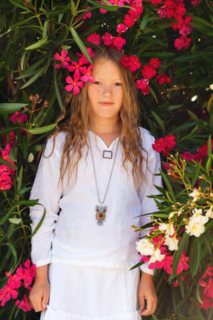 Adorable little girl playing with frangipani flowersの写真素材