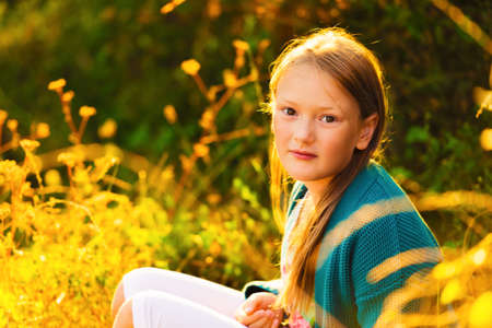 Outdoor portrait of a cute little girl of 8-9 years old at sunset