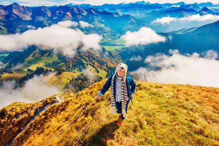Portrait of a cute little girl in mountains, wearing funny hat and blue jacket, Moleson-sur-Gruyeres, canton of Fribourg, Switzerlandの写真素材
