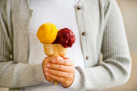 Double colorful ice cream in child's handの写真素材