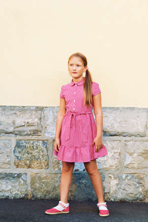 Outdoor portrait of cute little 8 year old girl, wearing red mary jane dressの写真素材