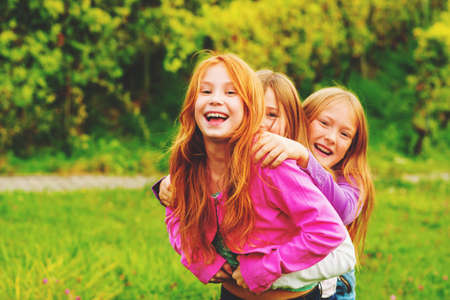 3 little girls having fun outdoorsの写真素材