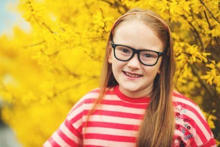 Outdoor portrait of a cute little girl in glassesの写真素材