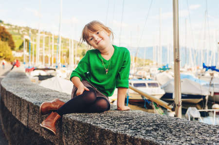 Fashion portrait of adorable 5 year old little girl resting by the lakeの写真素材