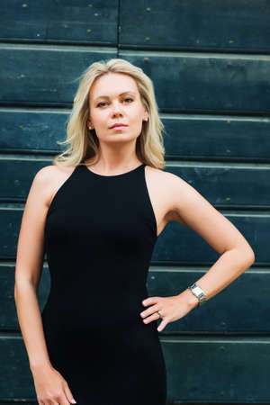 Outdoor portrait of young blond woman wearing black dressの写真素材