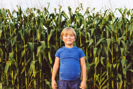 Sweet little 4-5 year old little boy playing in a countryside farmの写真素材
