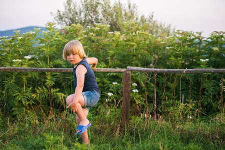 Little boy playing outdoors in countryside on a warm nice dayの写真素材