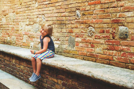 Handsome little boy tourist resting in the old street of Siena, Italyの写真素材