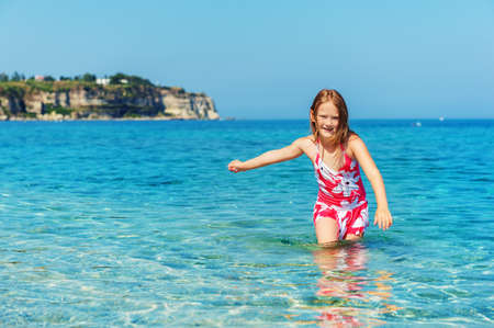 Happy little girl playing in the seaの写真素材