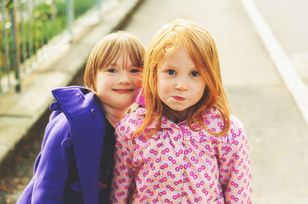 Outdoor portrait of two adorable toddler red hair girlsの写真素材