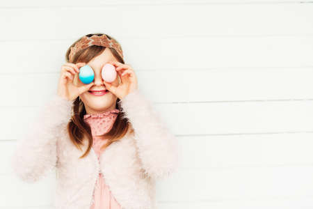 Close up spring portrait of beautiful little girl with easter eggsの写真素材