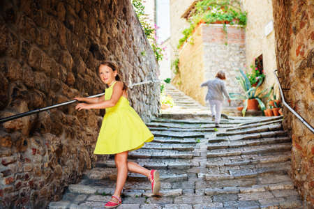 Adorable kids having fun outdoors, dancing on the streets of old italian cityの写真素材