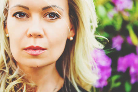 Portrait of beautiful blond woman in spring blossomの写真素材