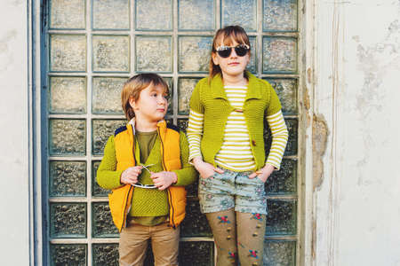 Two happy kids playing outdoors, fashion boy and girl posing on the streetの写真素材