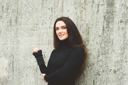 Outdoor portrait of young 35 year old woman with long dark hair, wearing black turtle neck dressの写真素材
