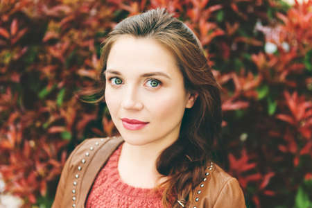 Close up portrait of beautiful young 25-30 year old woman with professional make up, wearing brown leather jacketの写真素材